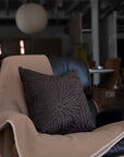 Dark brown sunburst throw pillow styled on white boucle sofa