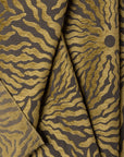 Gold and brown sunburst jacquard upholstery fabric by the yard, folded showing drape and weight