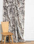 Black and cream marbled abstract linen fabric by the yard, draped to show pattern and scale