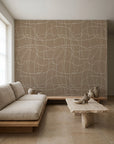 Cream hand-drawn grid on tan wallpaper installed in a minimalist living room