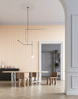 Modern dining room featuring putty neutral colored square grid patterned wallpaper, a sculptural wooden and metal dining table, minimalist wooden chairs, and a black sideboard against a neutral backdrop.