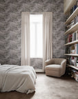 Serene bedroom featuring a soft purple botanical wallpaper, paired with neutral bedding, a plush beige armchair, and wooden bookshelves for a tranquil, cozy retreat.