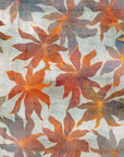 Abstract floral patterned wallpaper in soft green with overlapping red and orange flowers, creating a layered, painterly effect.