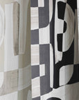 Angled shot showing the edges of black and white, tan, and green Down the Rabbit Hole wallpaper