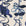 Close-up of grasscloth wallpaper with blue floral line drawings on a textured off-white background.