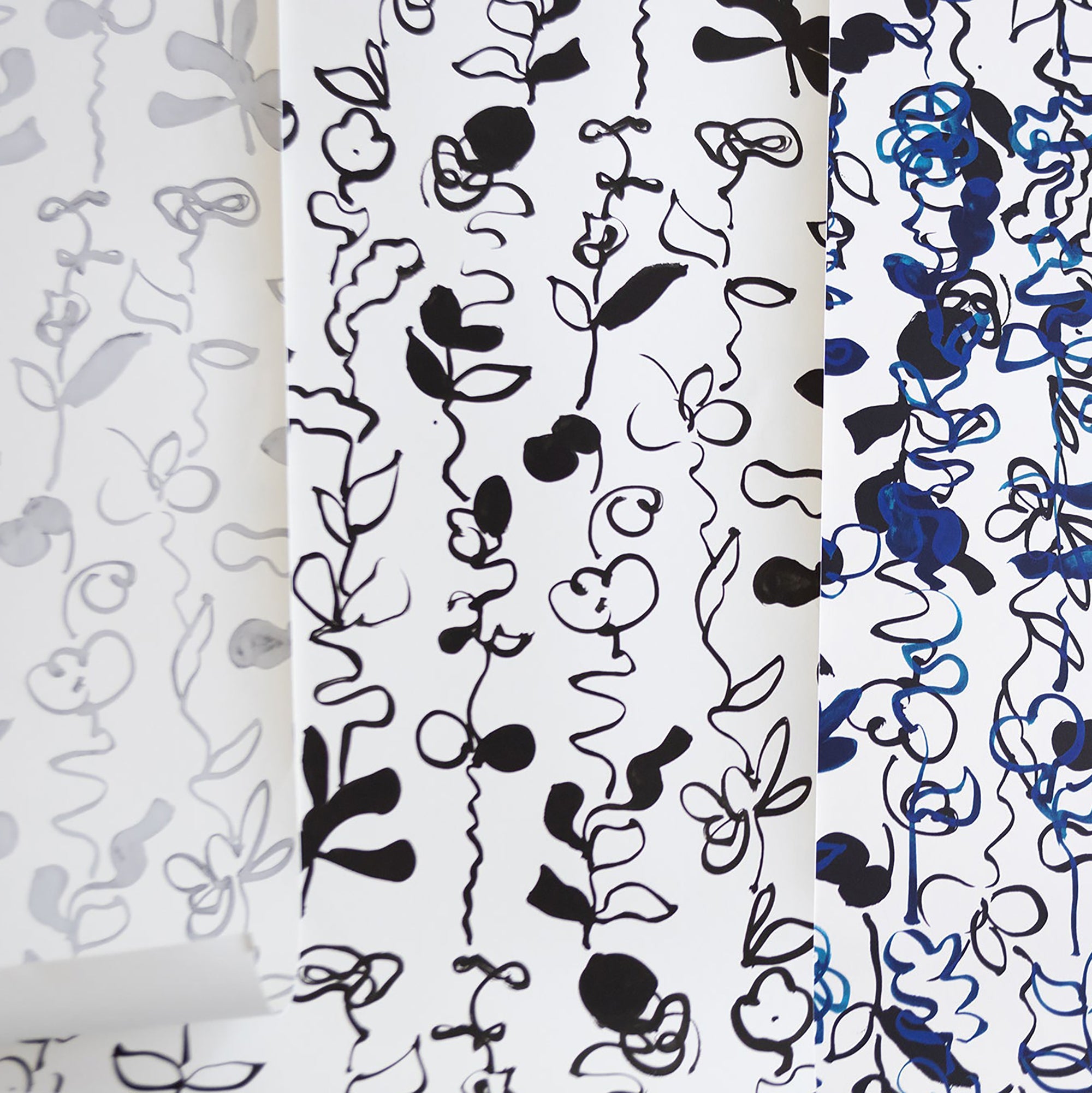 A collection of abstract floral patterned wallpapers in grayscale, black-and-white, and blue variations, featuring hand-drawn botanical elements on a white background.