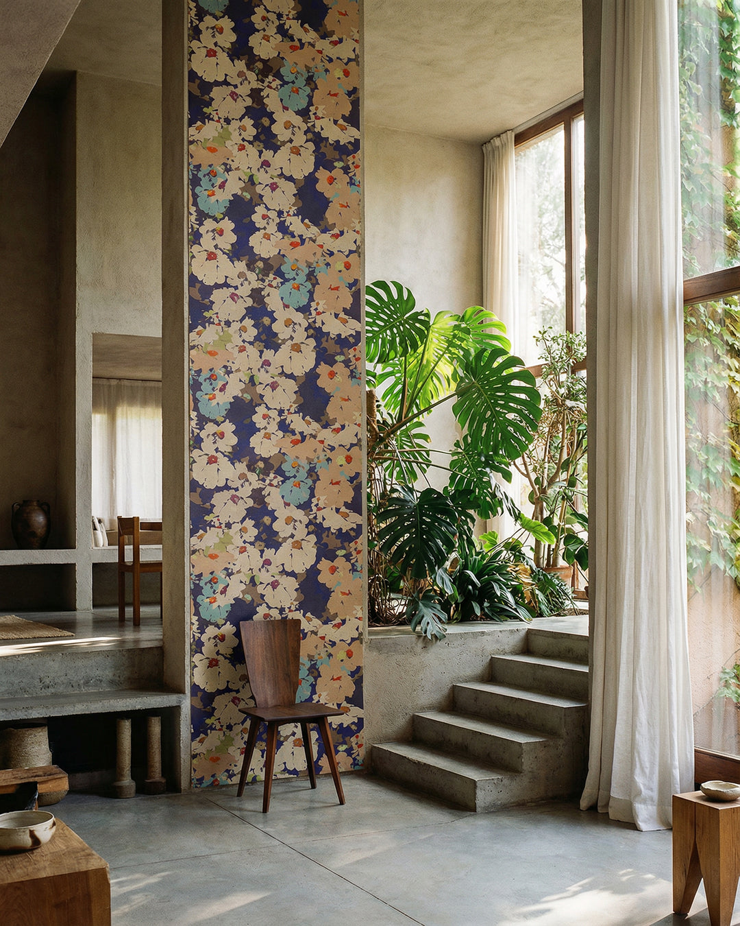Modern interior with a floral wall panel, wooden chair, and plants.