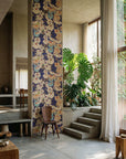 Modern interior with a floral wall panel, wooden chair, and plants.