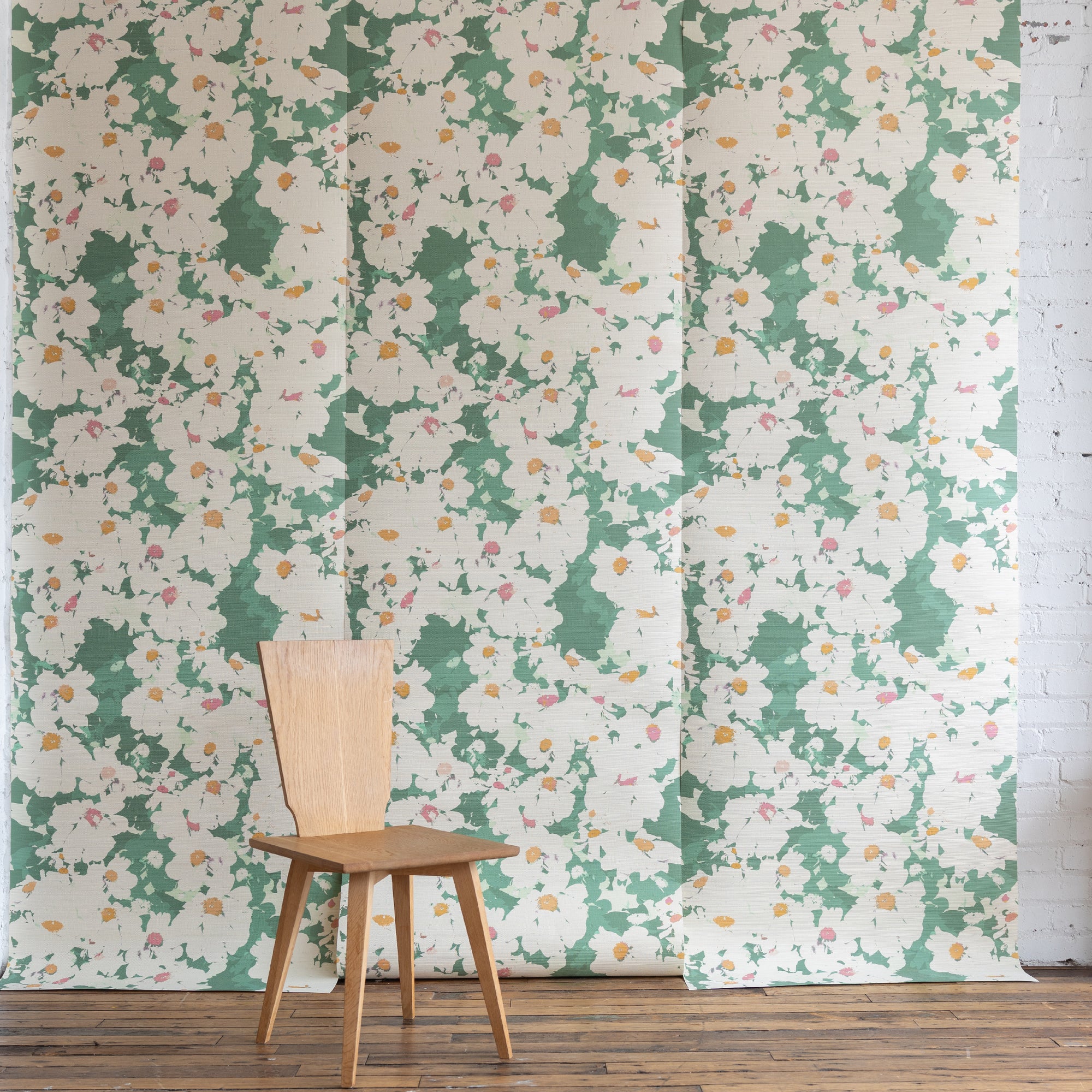 Floral grasscloth wallpaper with green background and wooden chair in front