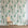 Floral grasscloth wallpaper with green background and wooden chair in front