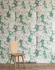 Floral grasscloth wallpaper with green background and wooden chair in front