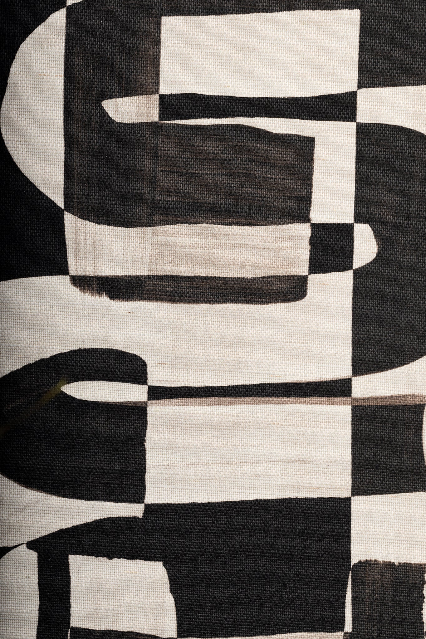 Detailed close-up of black and white grasscloth wallpaper, emphasizing the hand-painted brushstroke effect and natural weave texture.