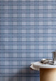 Styled kitchen setting with a marble and cork table against a blue plaid wallpaper, creating a cozy yet modern atmosphere