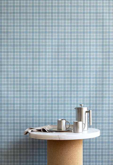 Interior scene showcasing vintage blue plaid check linen wallpaper, paired with a marble and cork pedestal table and stainless steel coffee accessories.