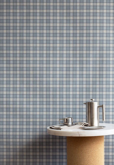 Interior styled with vintage plaid check linen wallpaper in dusty blue and cream, paired with a cork and marble pedestal table and stainless steel coffee accessories.
