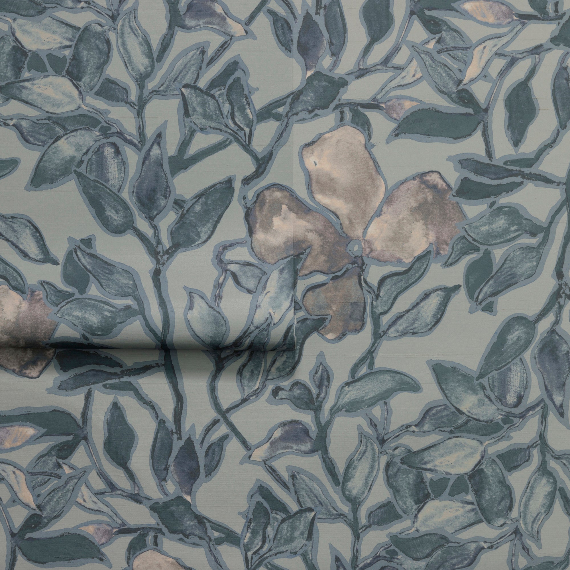 Rolled section of silk wallpaper showcasing a botanical pattern with blue leaves and beige flowers, emphasizing its texture and organic flow.
