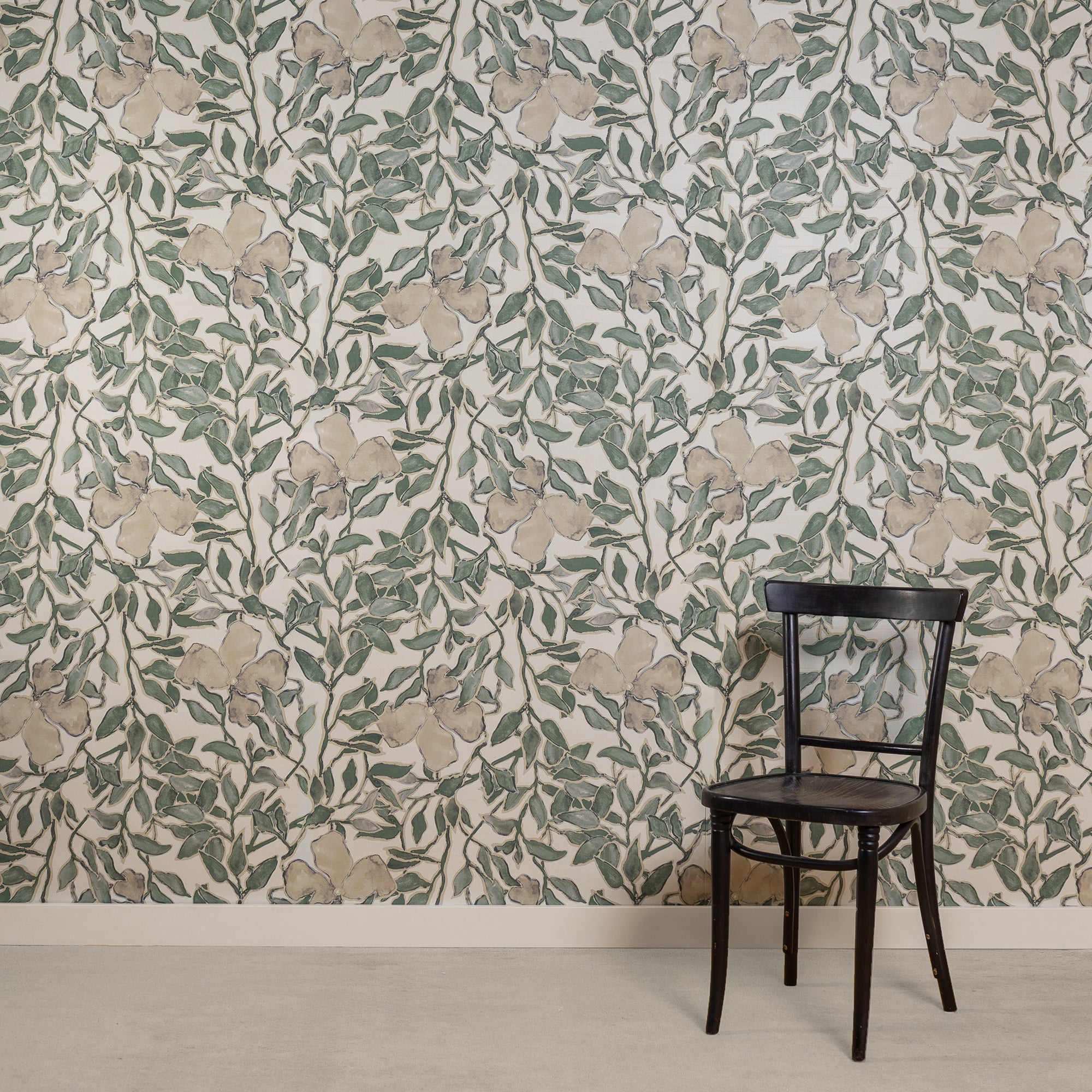 Room with silk wallpaper featuring a delicate botanical design in soft green and beige tones on a white background, depicting hand-painted flowers and leafy vines, complemented by a black wooden chair.