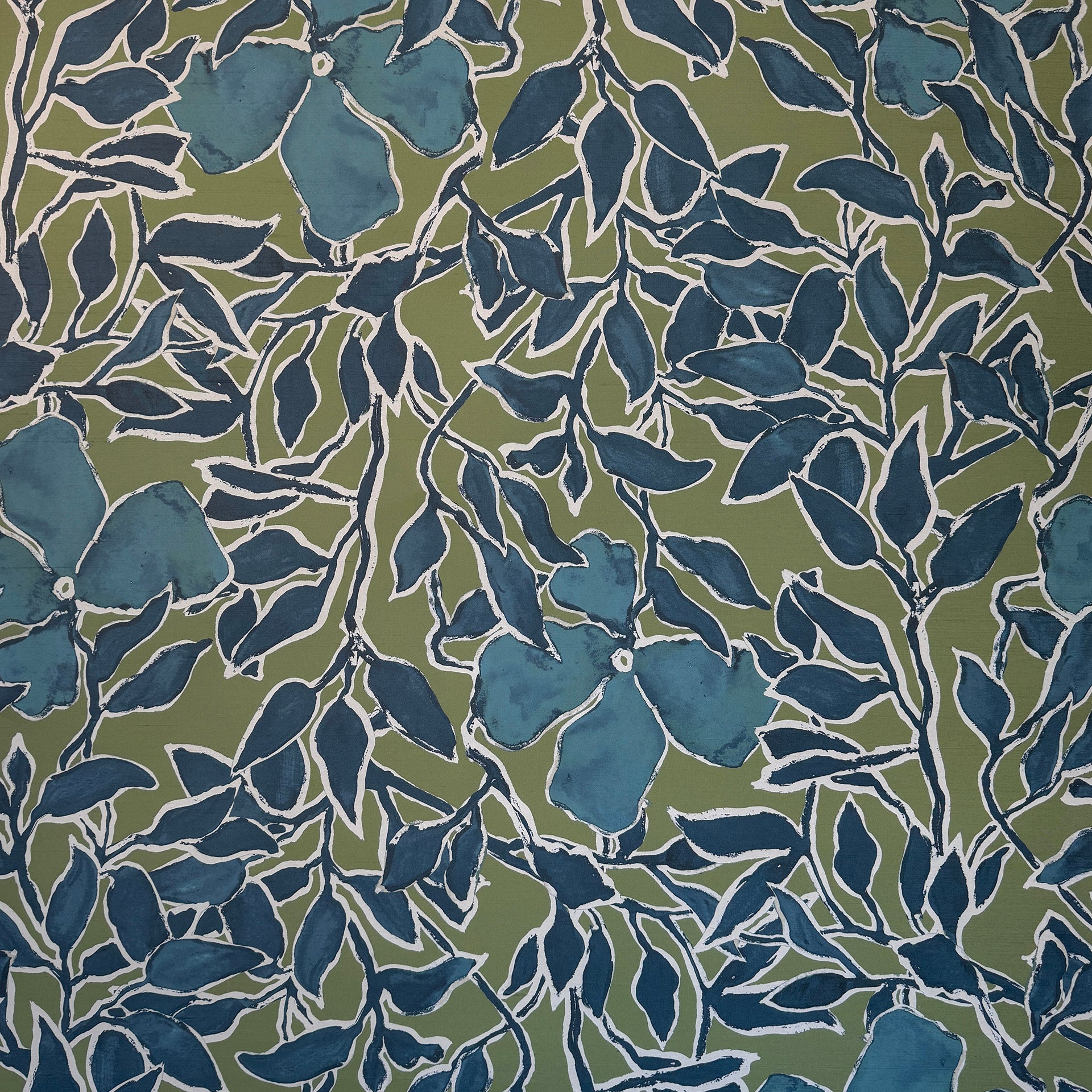 Vibrant silk wallpaper with a rich green background, deep blue leaves, and flowers outlined in white, creating a bold, hand-painted botanical pattern.