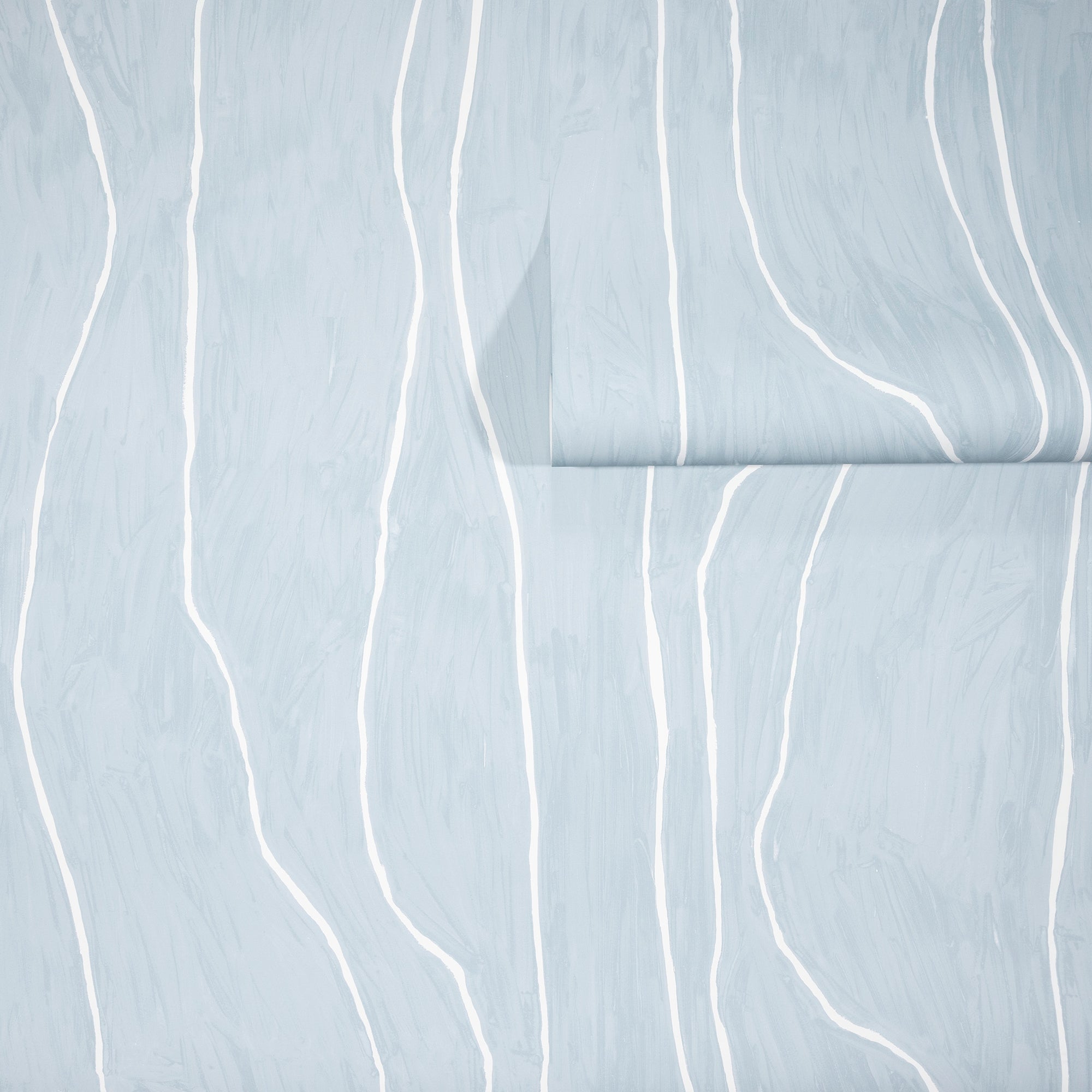 Light blue wallpaper with abstract white wavy vertical lines, partially unrolled to showcase the soft, organic pattern.