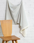 Light blue and cream striped linen fabric by the yard, draped to show pattern and scale