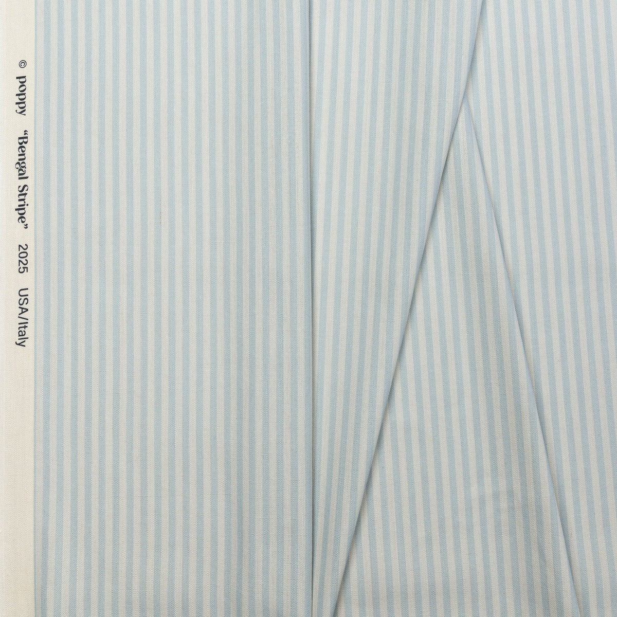 Light blue and cream striped linen fabric by the yard, folded showing drape and weight