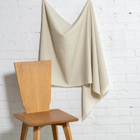 Sage green and cream striped linen fabric by the yard, draped to show pattern and scale