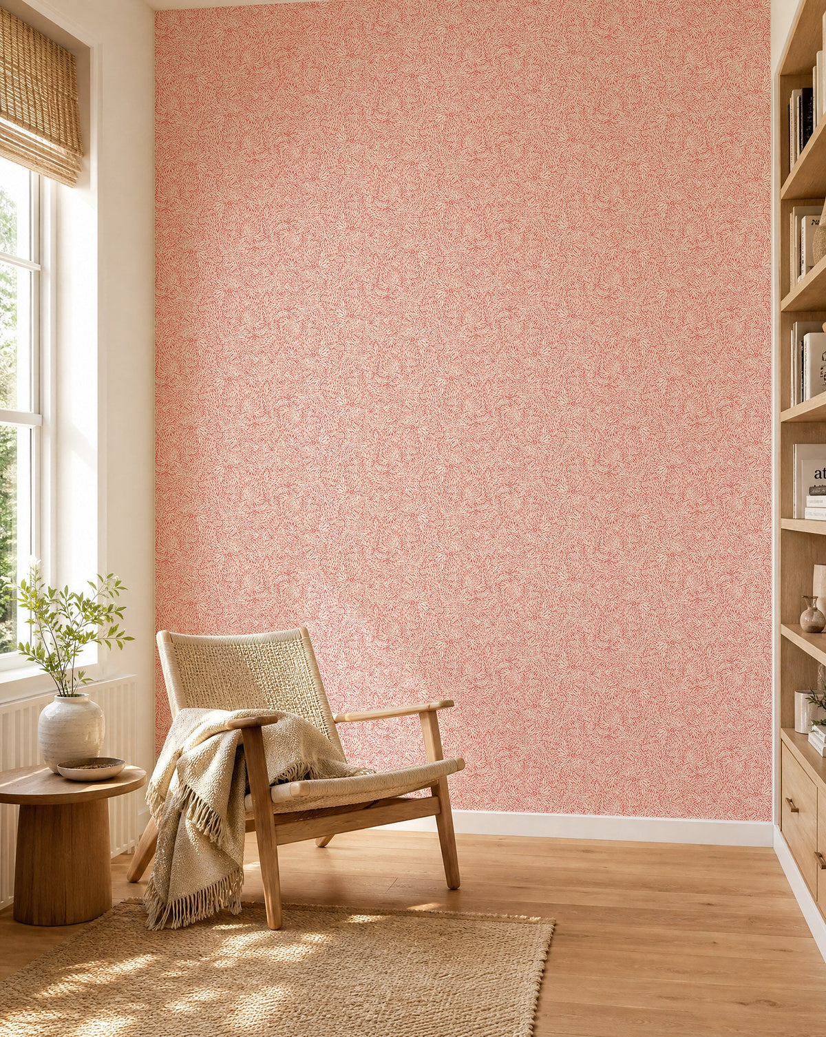 Coral and cream leafy floral commercial wallcovering installed in a sunlit reading nook