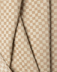 Cream and tan checkerboard jacquard upholstery fabric by the yard, folded showing drape and weight