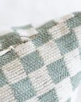 Close-up of woven checkerboard pattern on olive green and cream chenille jacquard throw pillow