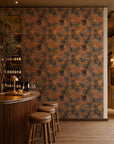 Gray-blue floral on orange wallpaper installed behind a wine bar
