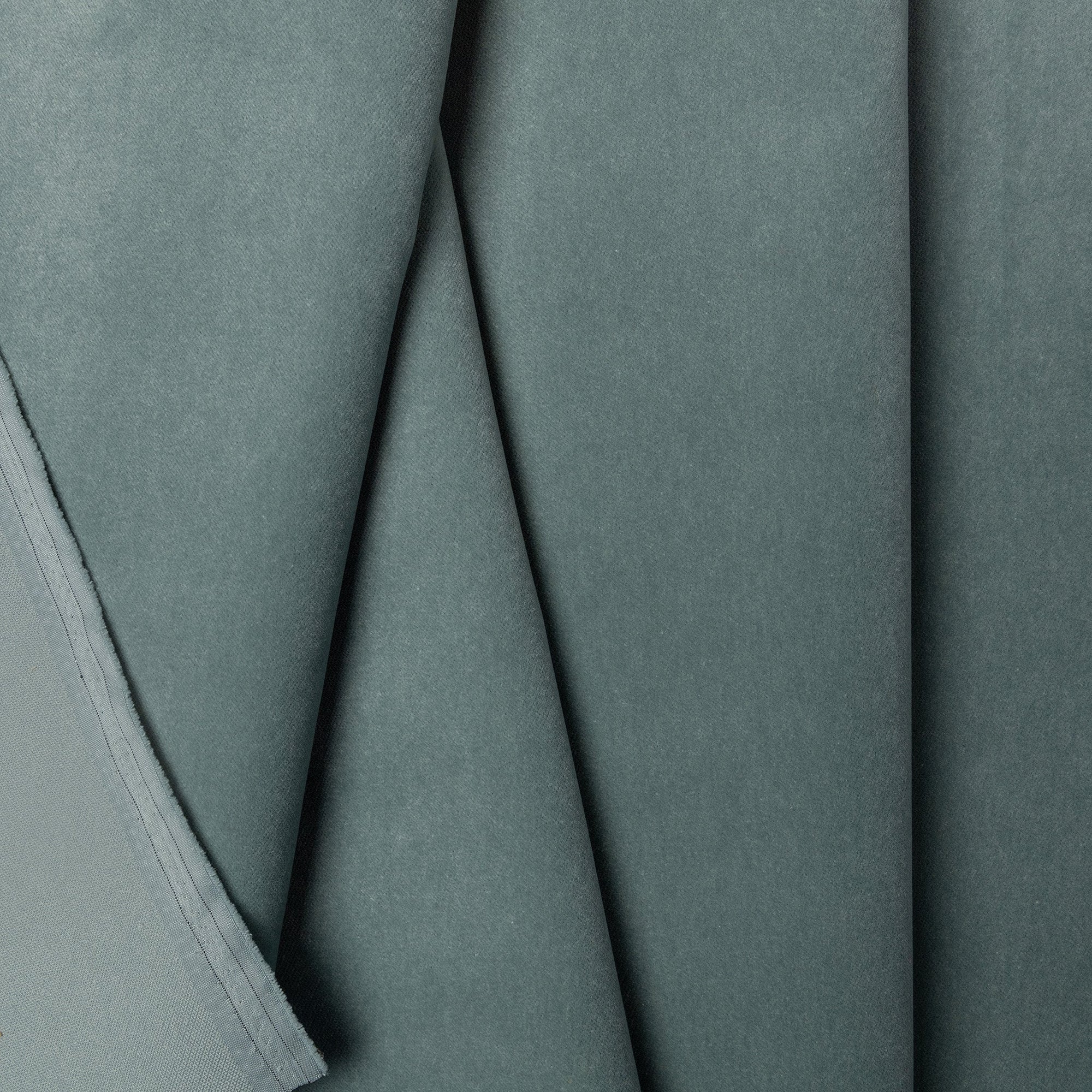 Green velveteen upholstery fabric by the yard, folded showing drape and weight