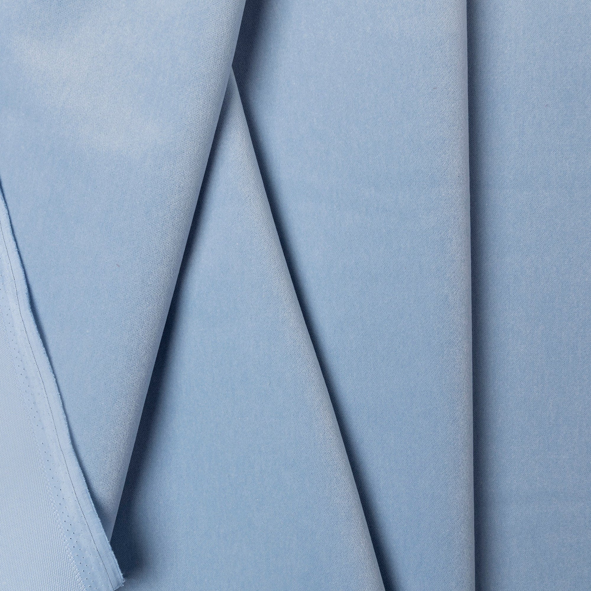 Light blue velveteen upholstery fabric by the yard, folded showing drape and weight