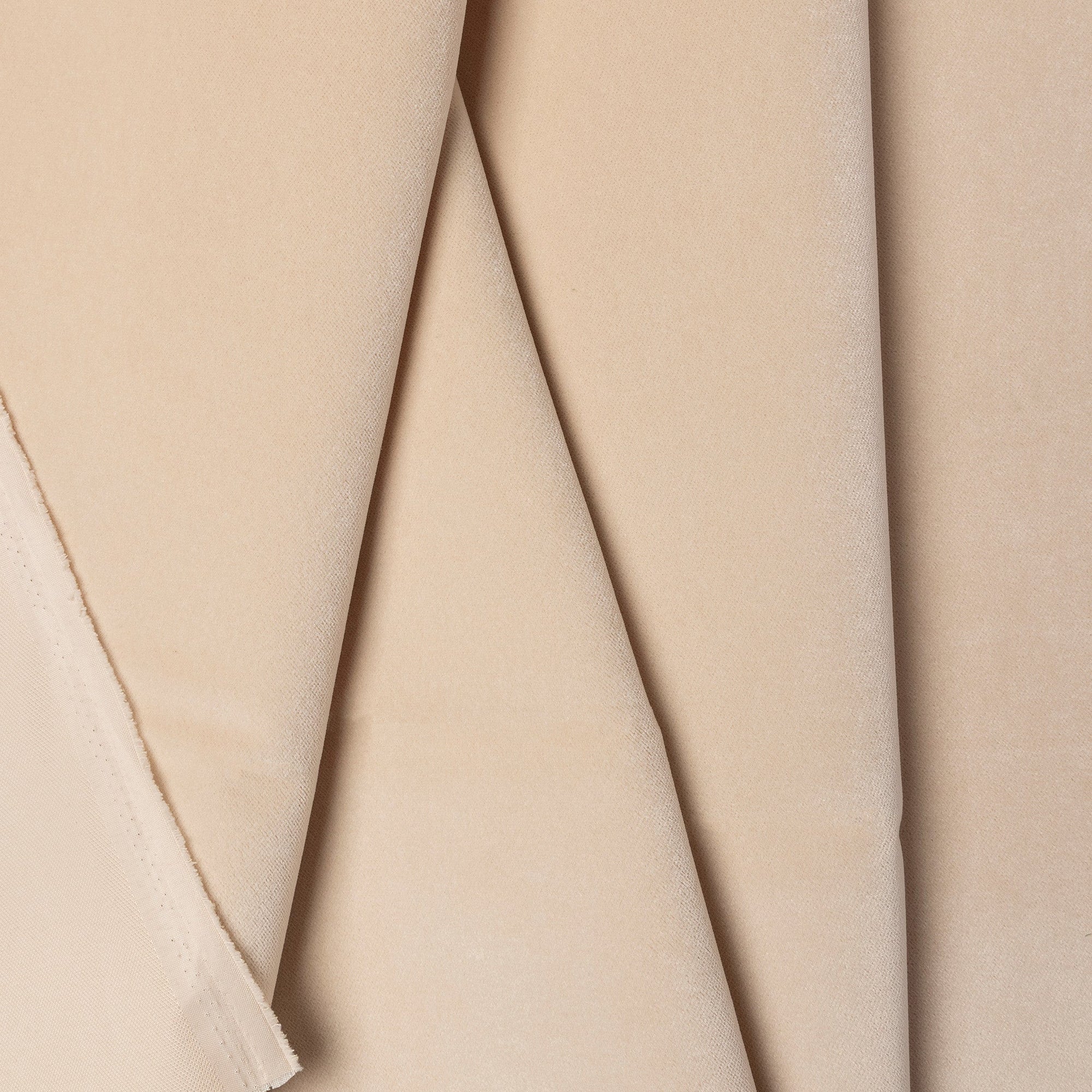 Beige velveteen upholstery fabric by the yard, folded showing drape and weight