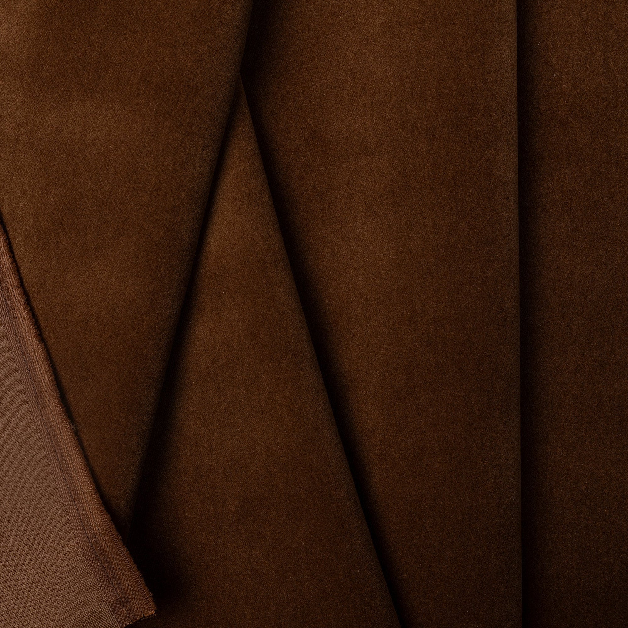 Dark brown velveteen upholstery fabric by the yard, folded showing drape and weight