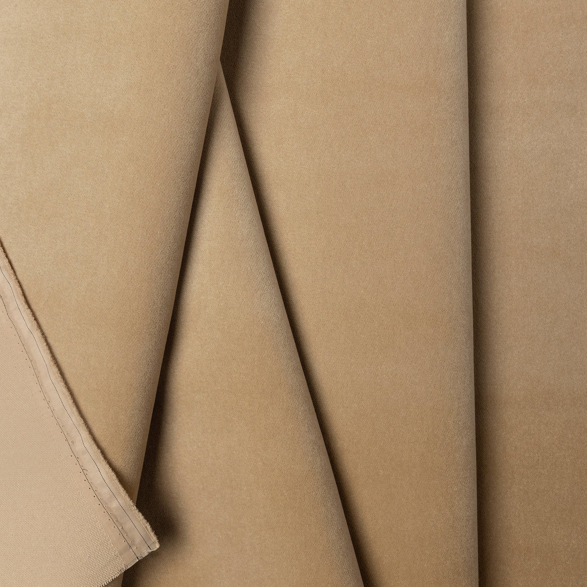 Tan velveteen upholstery fabric by the yard, folded showing drape and weight