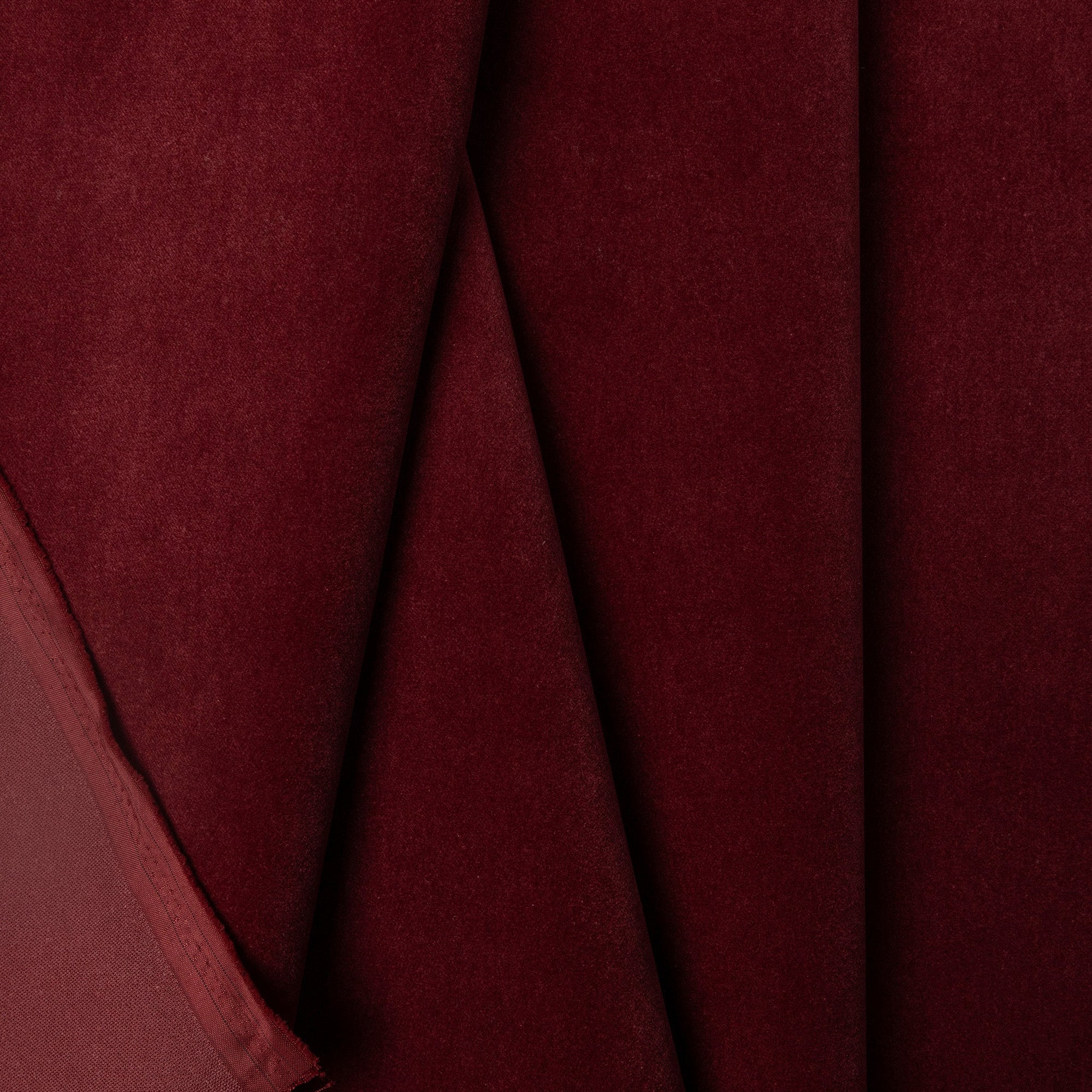 Burgundy velveteen upholstery fabric by the yard, folded showing drape and weight