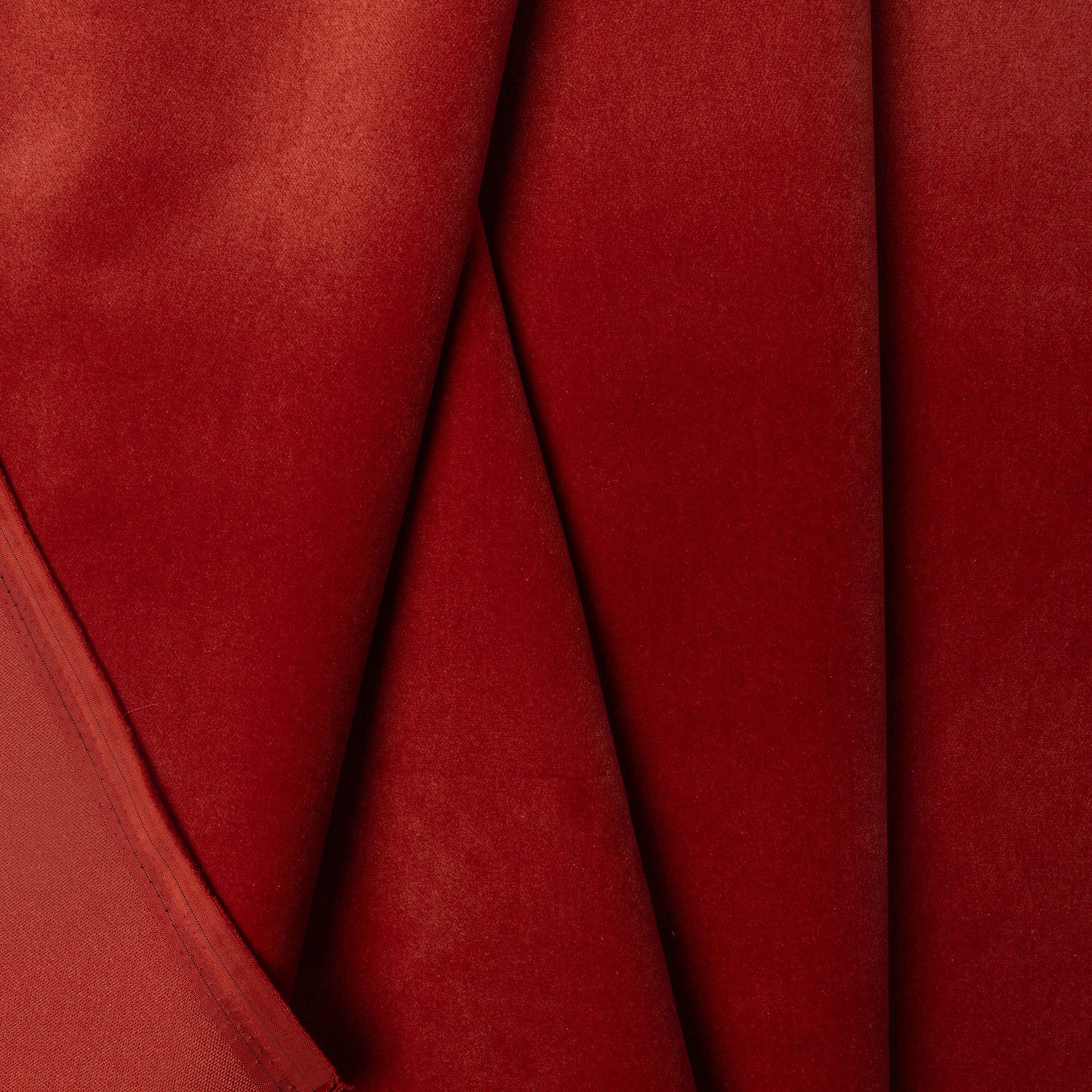 Red velveteen upholstery fabric by the yard, folded showing drape and weight