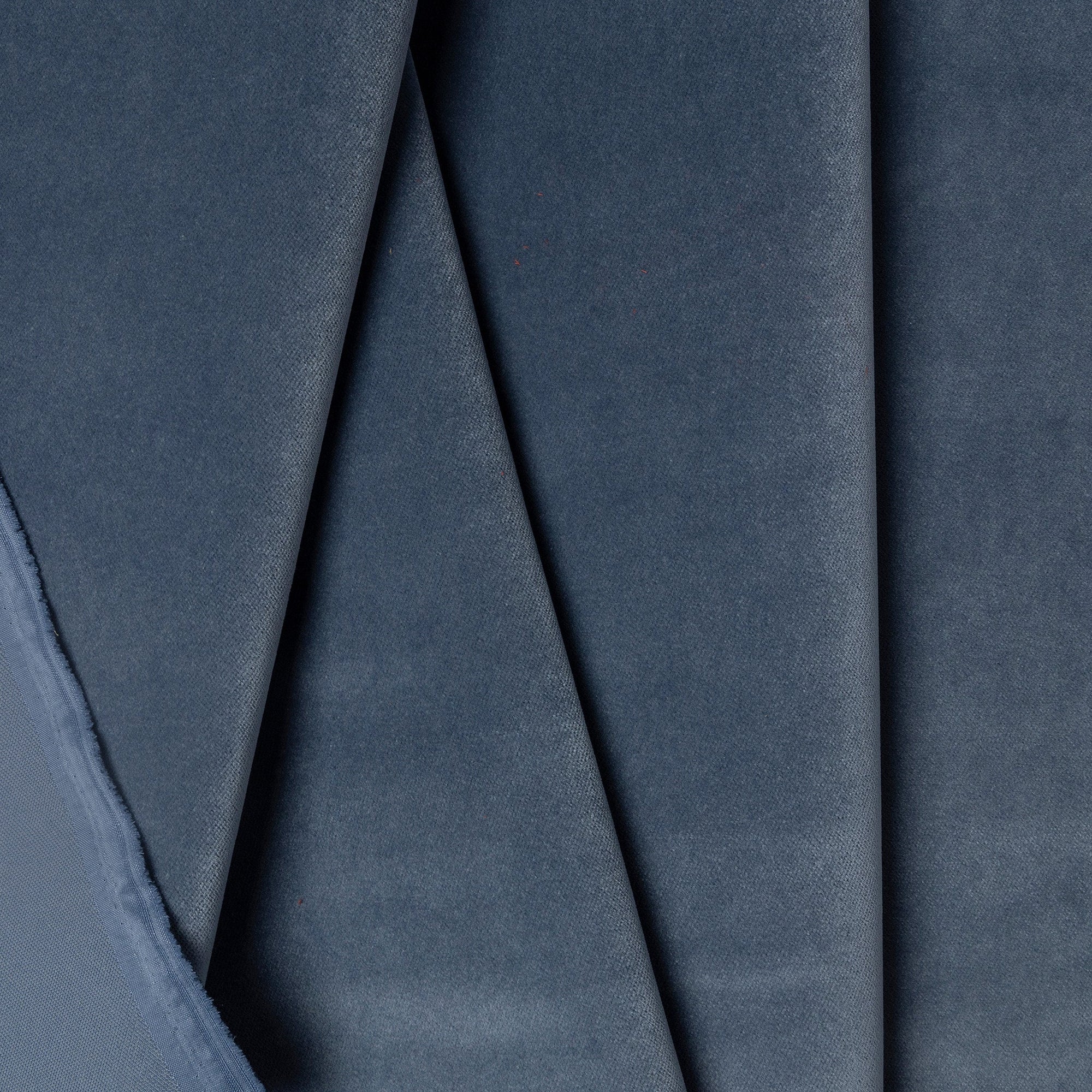 Blue velveteen upholstery fabric by the yard, folded showing drape and weight