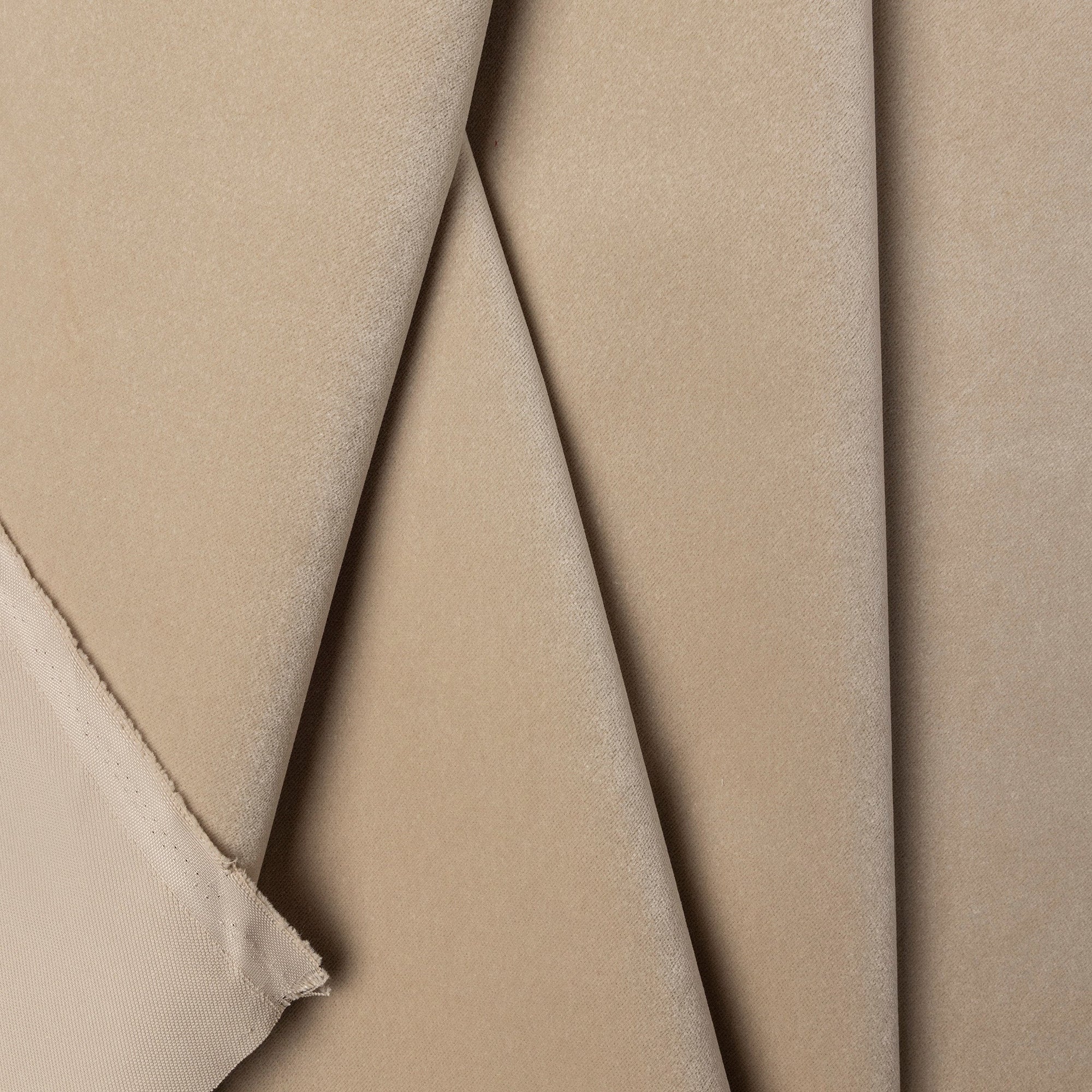 Beige velveteen upholstery fabric by the yard, folded showing drape and weight