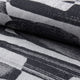 Black and gray abstract jacquard upholstery fabric by the yard, rolled bolt view