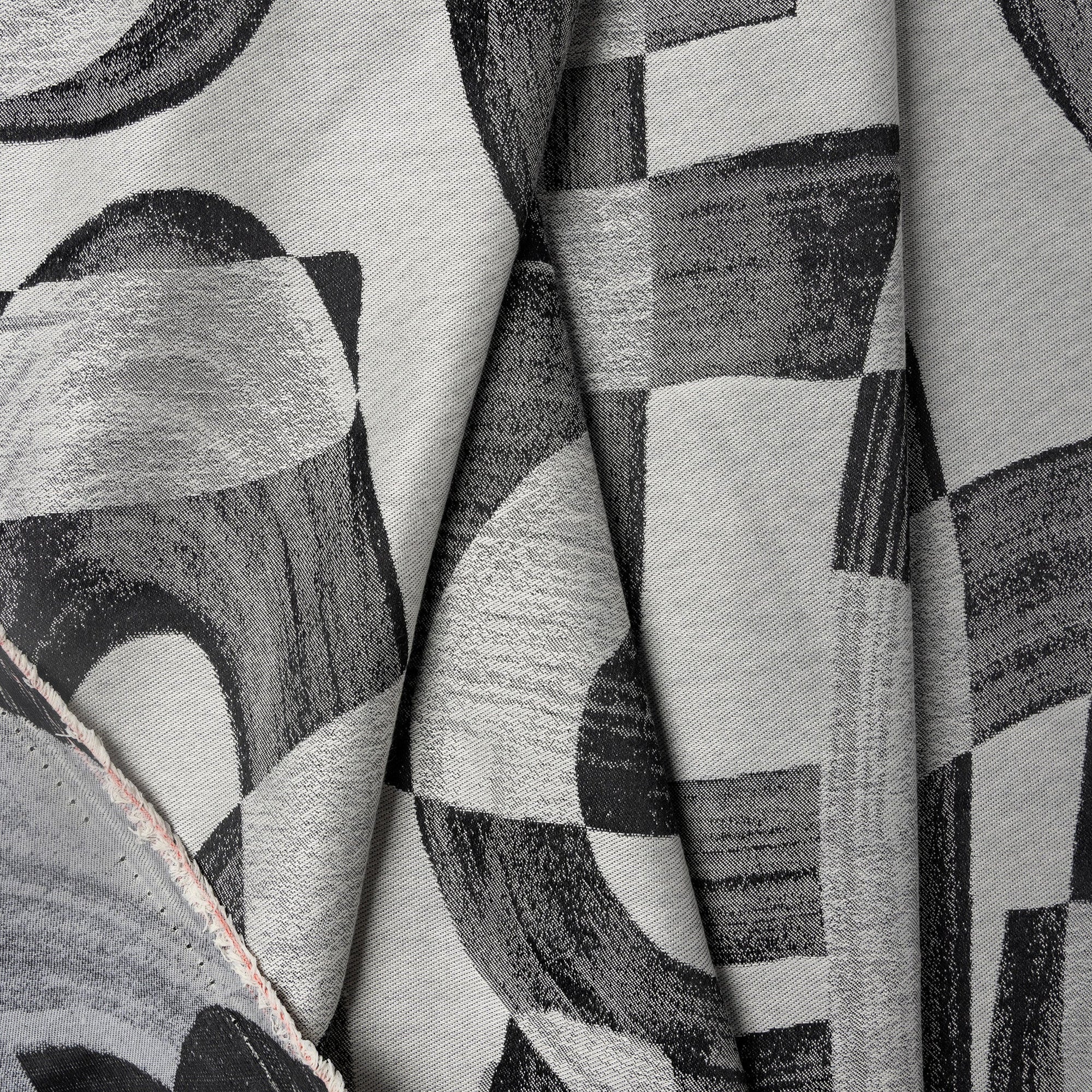 Black and gray abstract jacquard upholstery fabric by the yard, folded showing drape and weight
