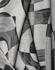 Black and gray abstract jacquard upholstery fabric by the yard, folded showing drape and weight