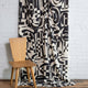 Black and cream abstract printed linen fabric by the yard, draped to show pattern and scale