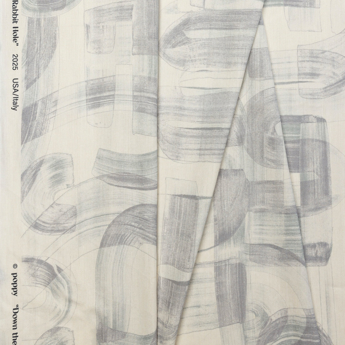 Gray and cream abstract printed linen fabric by the yard, folded showing drape and weight