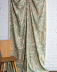 Sage green and cream abstract printed linen fabric by the yard, draped to show pattern and scale