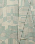 Sage green and cream abstract printed linen fabric by the yard, folded showing drape and weight