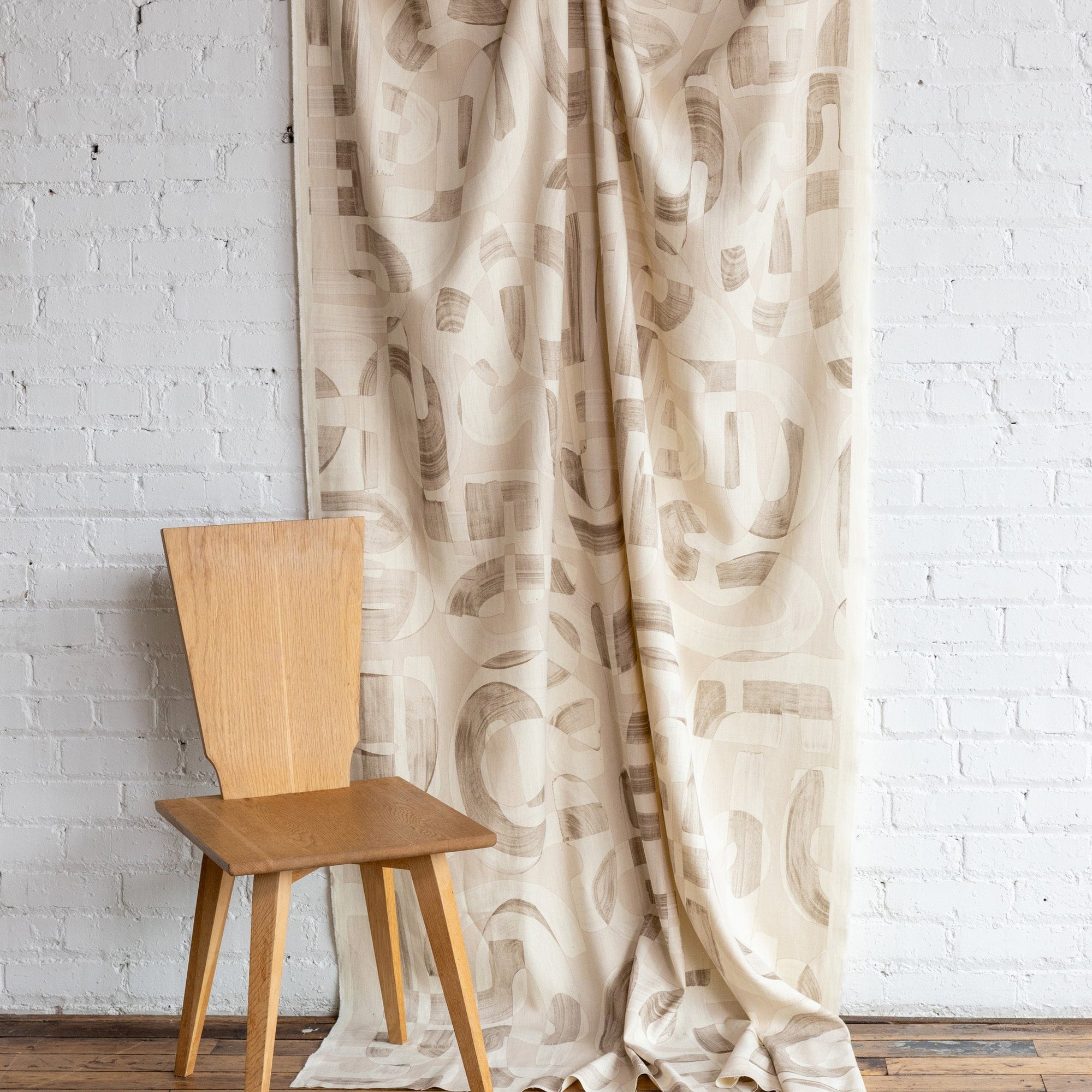 Beige and cream abstract printed linen fabric by the yard, draped to show pattern and scale