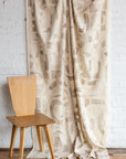 Beige and cream abstract printed linen fabric by the yard, draped to show pattern and scale