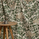 Cream and green floral printed linen fabric by the yard, draped to show pattern and scale