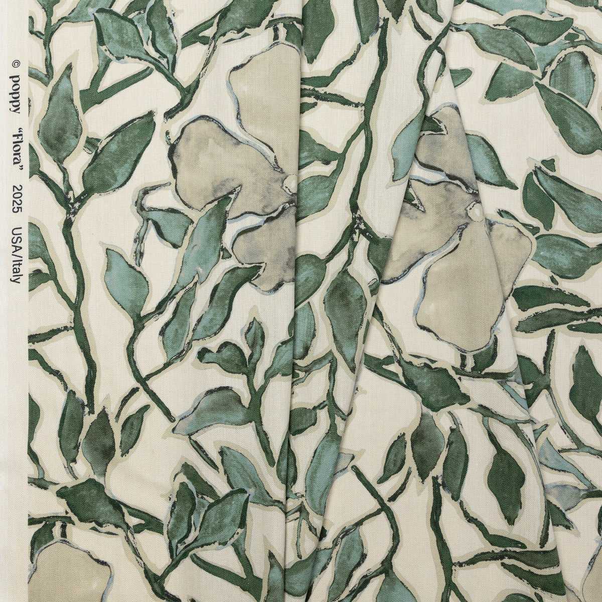 Cream and green floral printed linen fabric by the yard, folded showing drape and weight